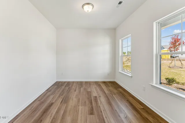 a view of room with window and wooden floor