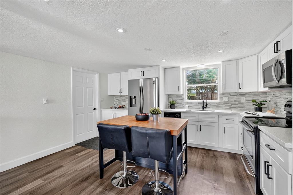 11119 Temple Avenue Seminole, FL 33772 - Photo 12 of 35 a view of a dining room with furniture and wooden floor