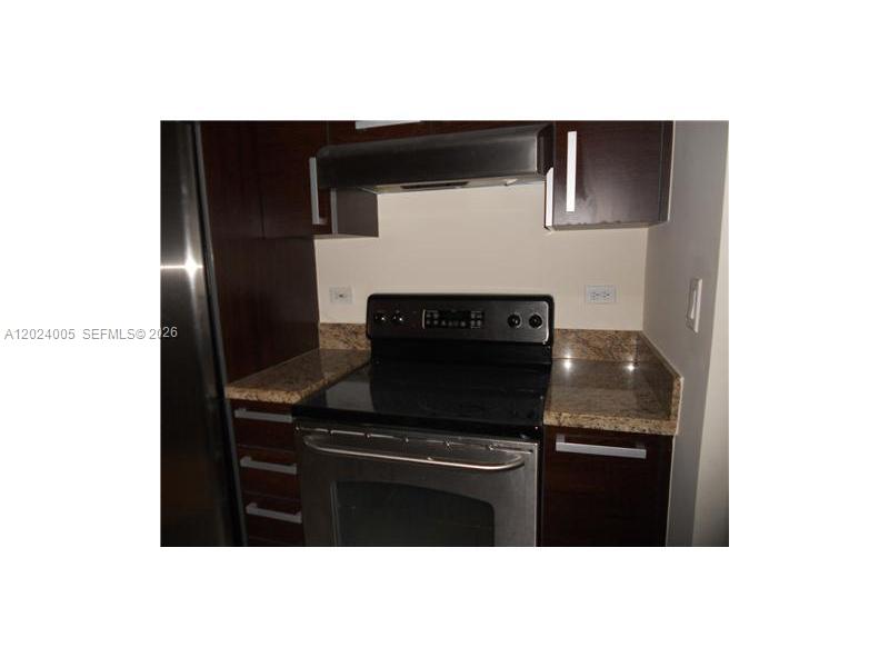 2525 Southwest 3rd Avenue, Unit 1006 Miami, FL 33129 - Photo 3 of 13 a kitchen with a sink and stainless steel appliances