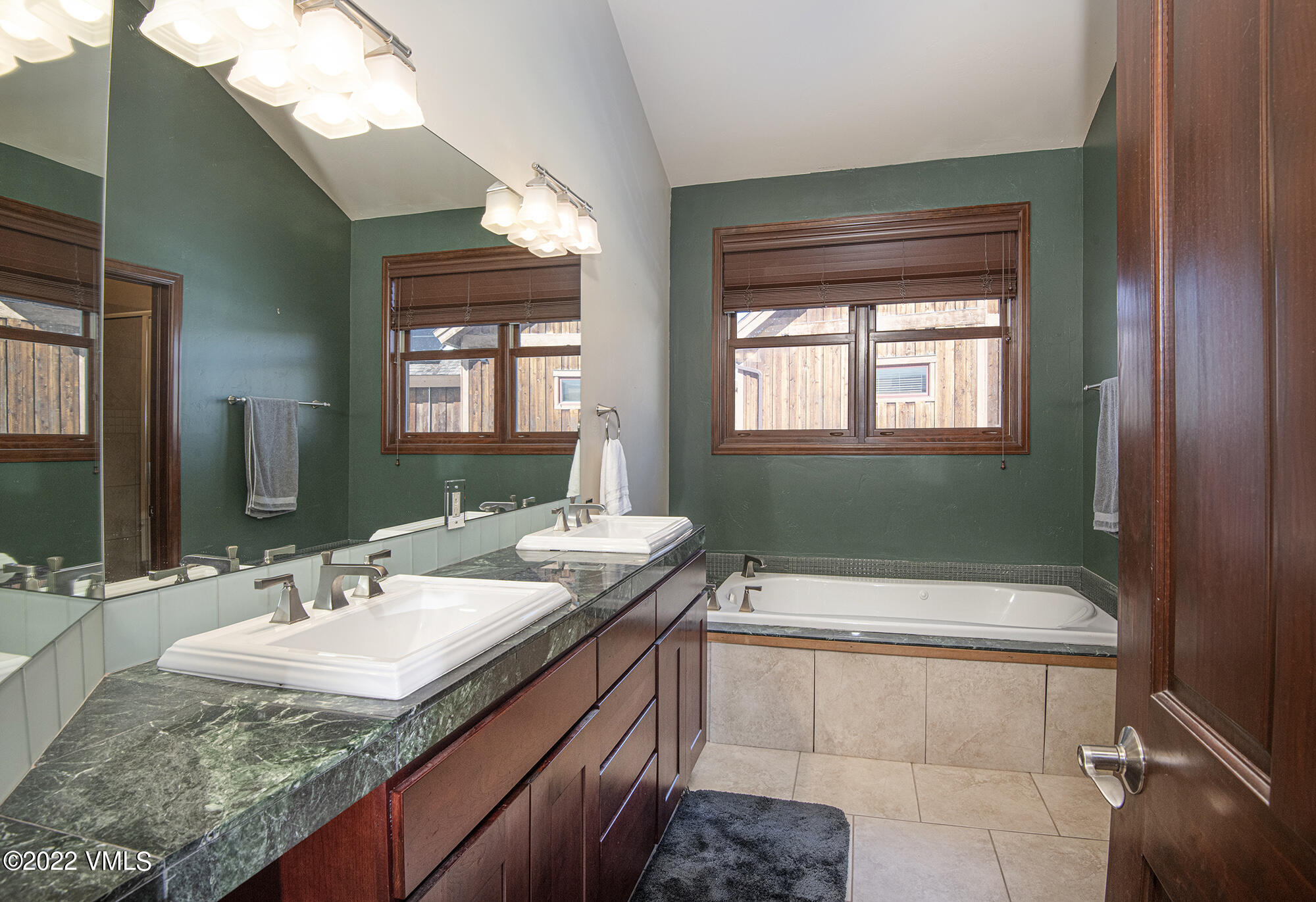 213 Bluffs Drive Eagle, CO 81631 - Photo 12 of 35 a bathroom with a granite countertop sink a mirror and a bathtub