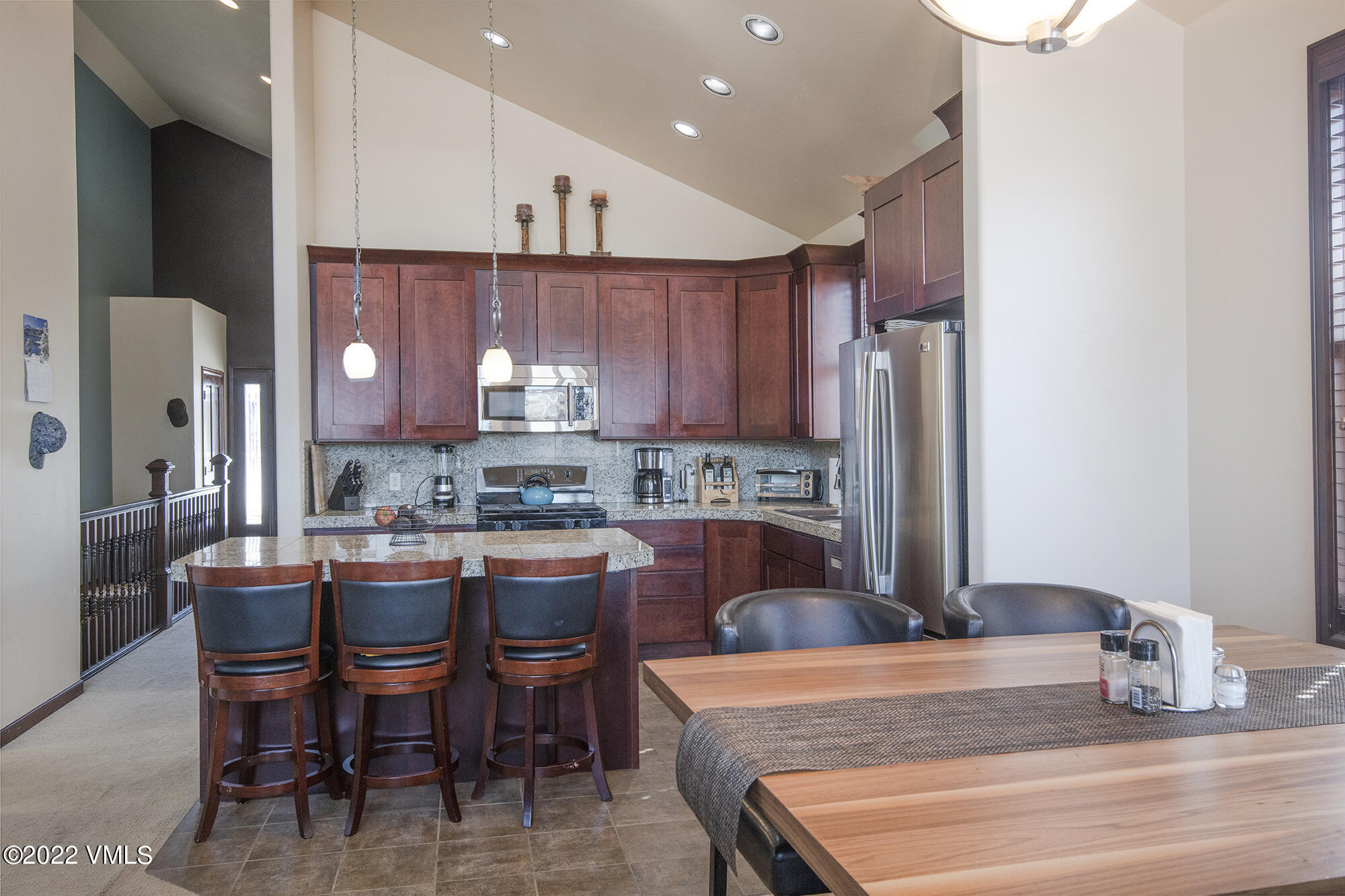 213 Bluffs Drive Eagle, CO 81631 - Photo 7 of 35 a kitchen with stainless steel appliances granite countertop a table chairs sink refrigerator and cabinets
