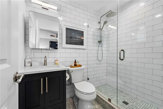 a bathroom with a granite countertop toilet sink and mirror