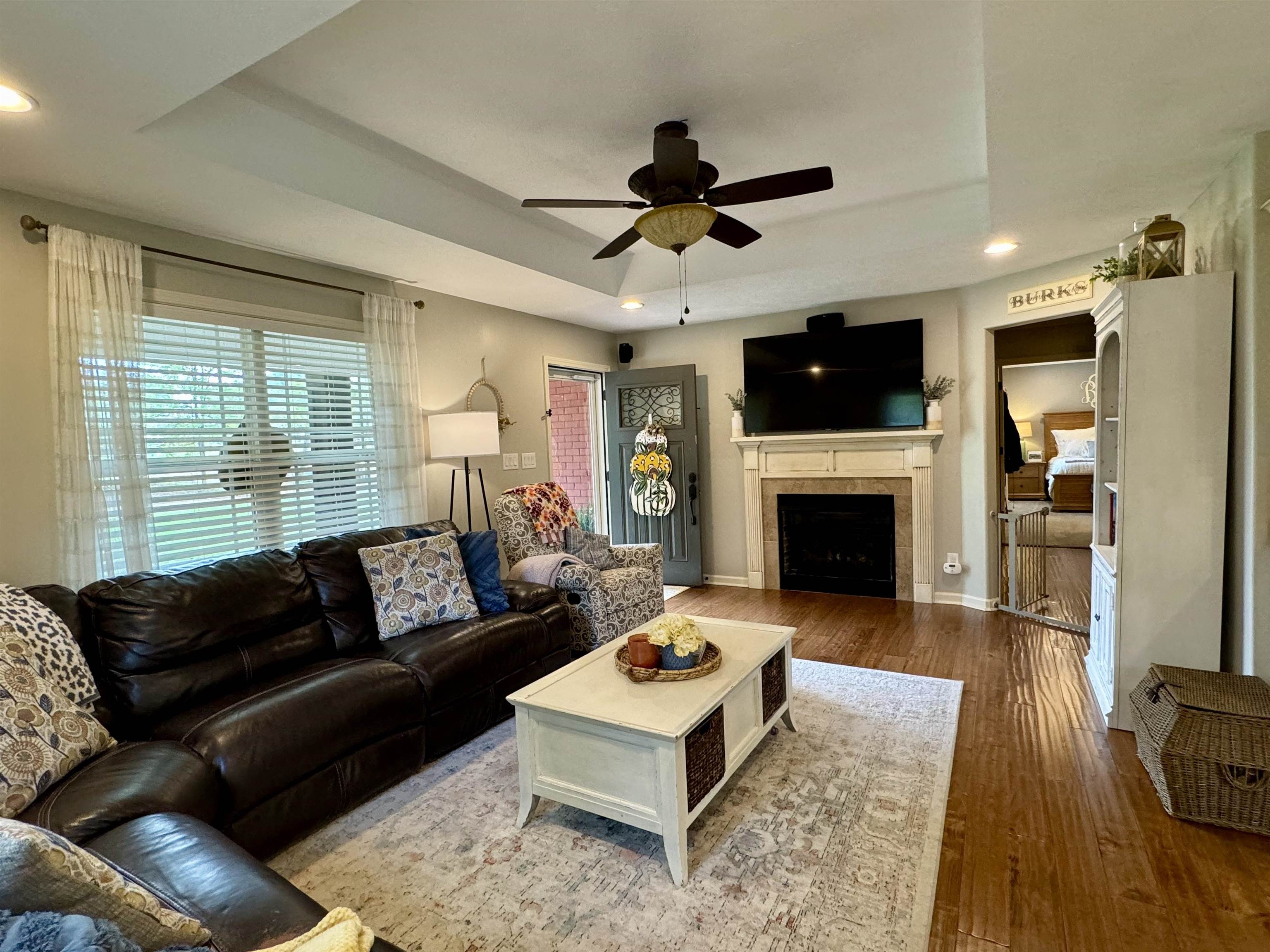 40 Foxtrot Road Adamsville, TN 38310 - Photo 14 of 39 Living area with ceiling fan, wood finished floors, a tiled fireplace, and a raised ceiling