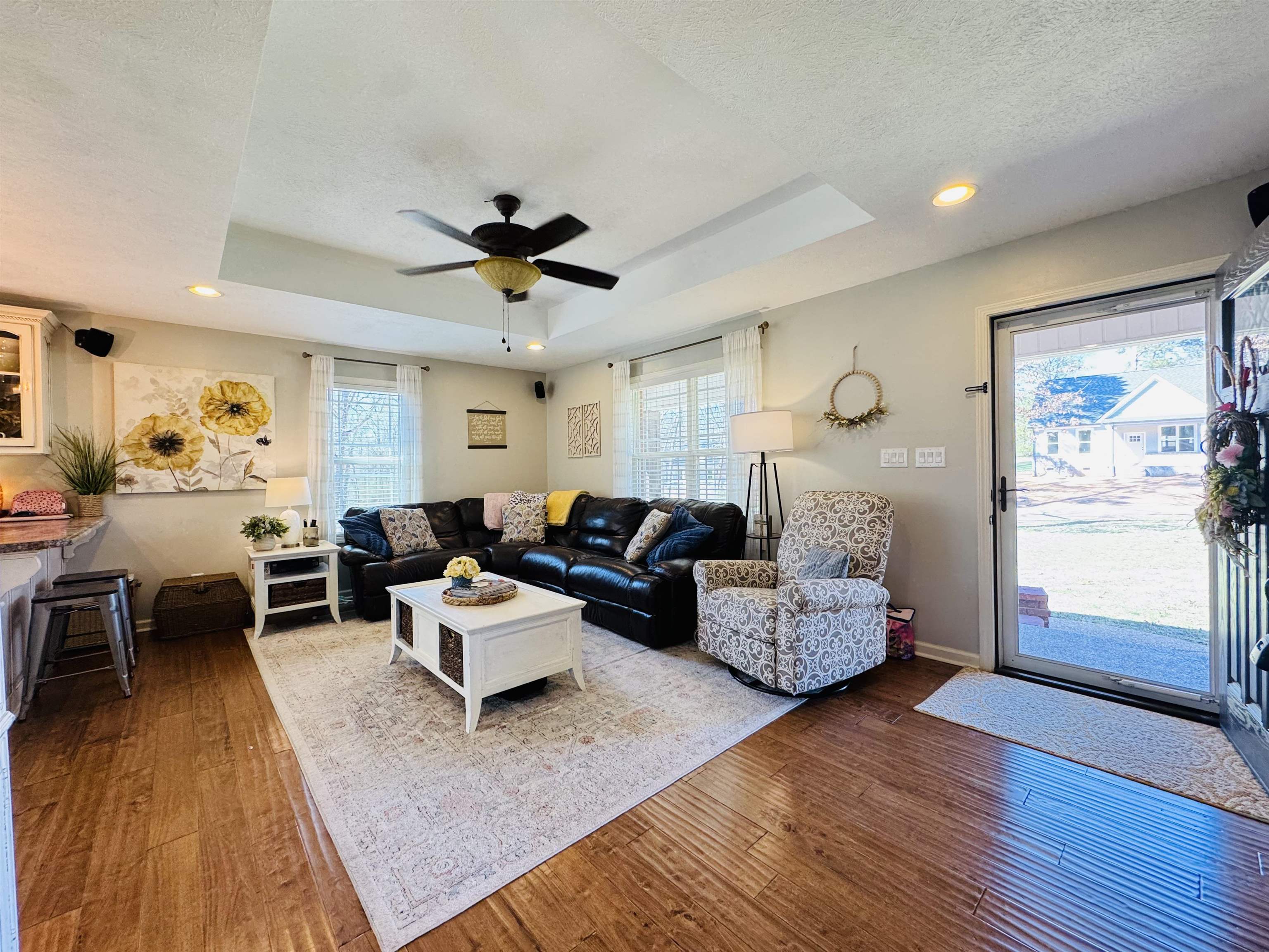 40 Foxtrot Road Adamsville, TN 38310 - Photo 15 of 39 Living room with wood-type flooring, a raised ceiling, and a healthy amount of sunlight
