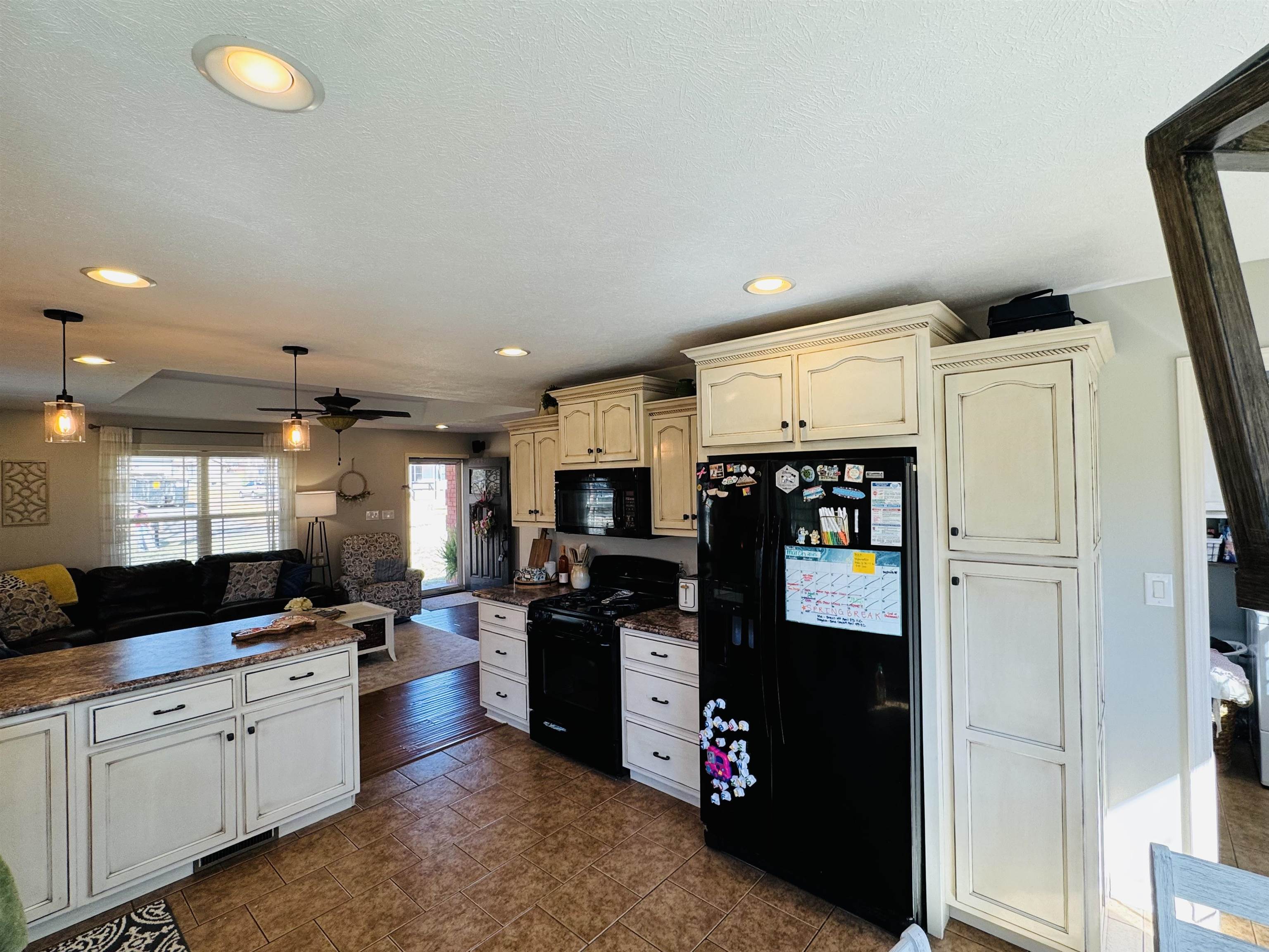 40 Foxtrot Road Adamsville, TN 38310 - Photo 39 of 39 Kitchen with cream cabinetry, ceiling fan, open floor plan, hanging light fixtures, and black appliances