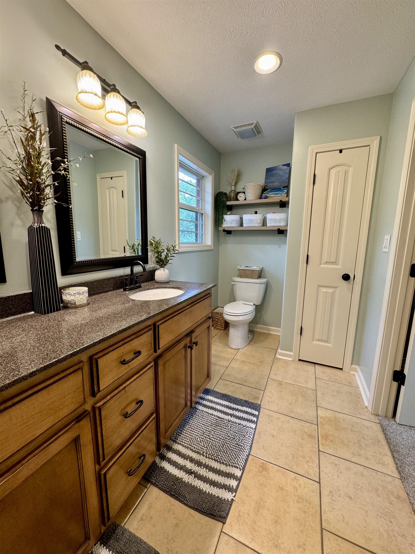 40 Foxtrot Road Adamsville, TN 38310 - Photo 21 of 39 Bathroom featuring a textured ceiling, visible vents, toilet, vanity, and tile patterned flooring