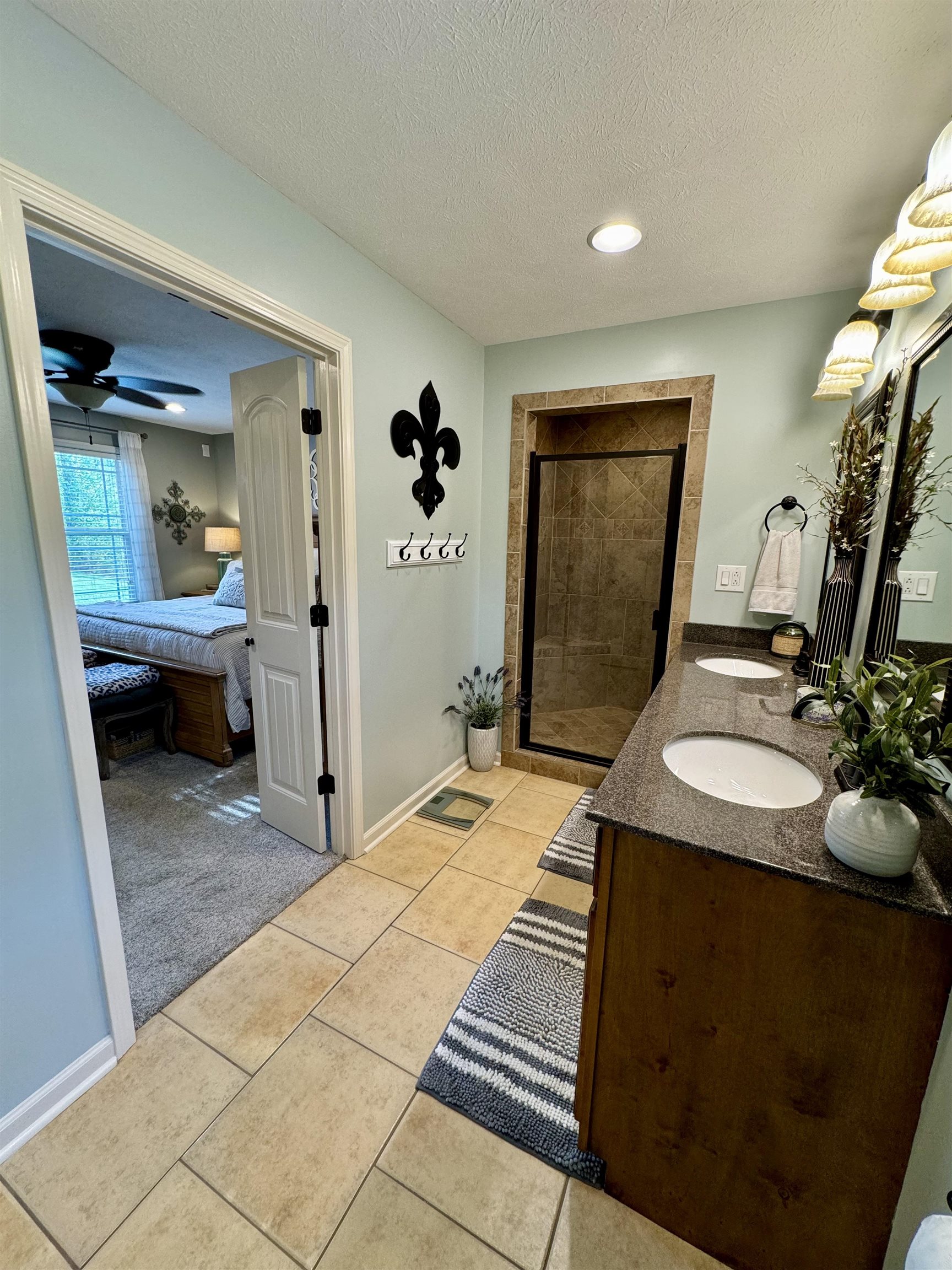 40 Foxtrot Road Adamsville, TN 38310 - Photo 22 of 39 Ensuite bathroom featuring a stall shower, a sink, a textured ceiling, tile patterned flooring, and double vanity