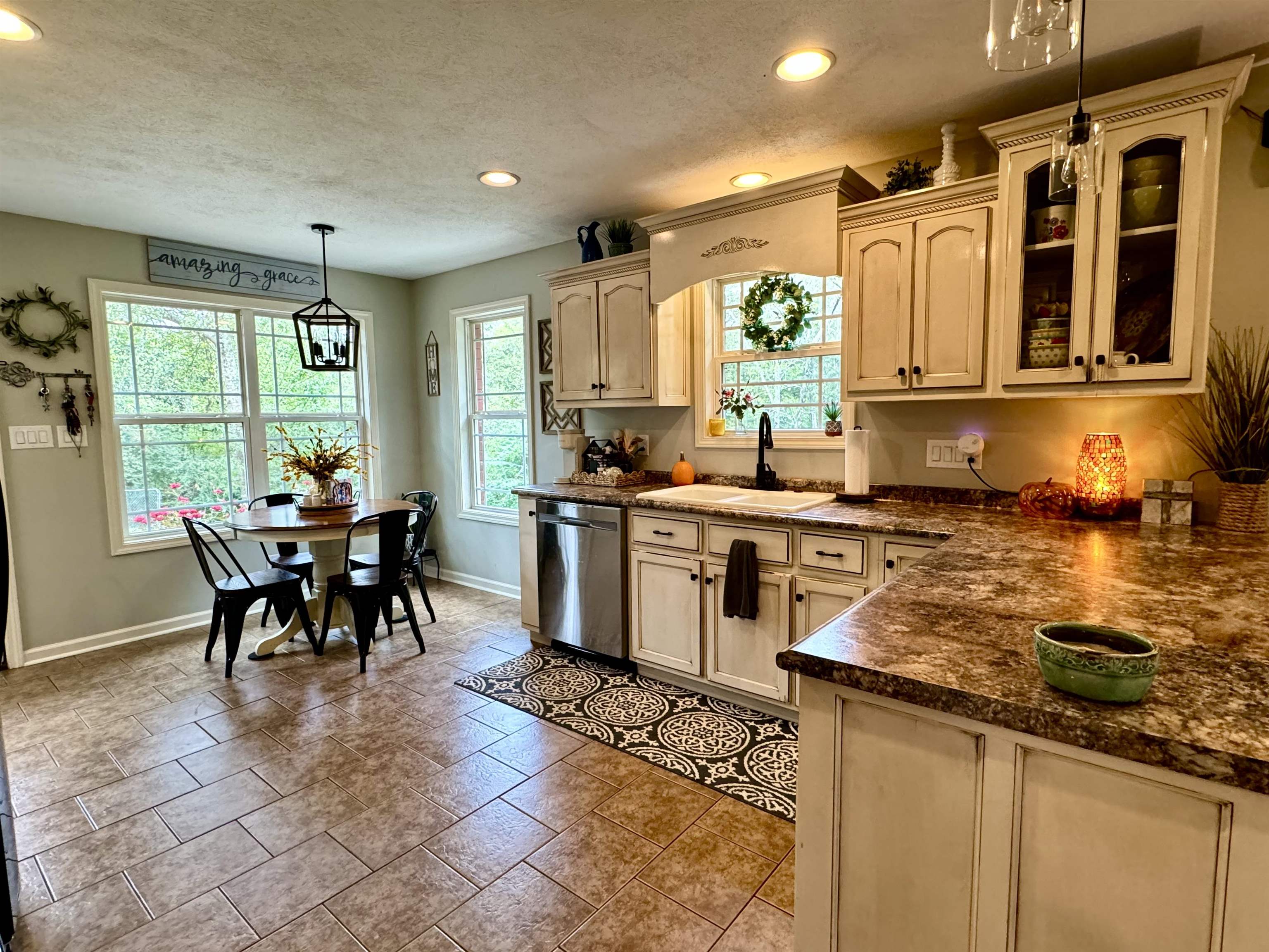 40 Foxtrot Road Adamsville, TN 38310 - Photo 34 of 39 Kitchen featuring baseboards, stainless steel dishwasher, a sink, dark countertops, and glass insert cabinets