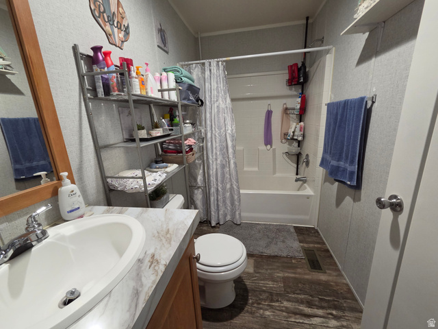 597 North State Street, Unit 67 Orem, UT 84057 - Photo 21 of 23 Bathroom with vanity, dark wood-style floors, shower / bath combo with shower curtain, and a textured wall