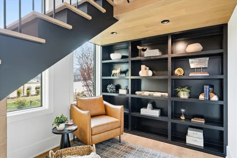 a living room with fireplace furniture and a large window