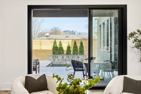 a view of a hallway with wooden floor and a living room