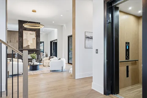 a bathroom with a toilet a sink a large mirror and a window