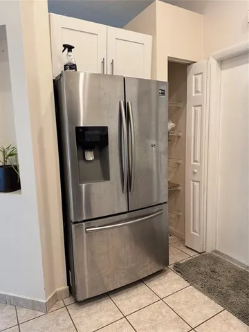 a metallic refrigerator freezer sitting in a kitchen