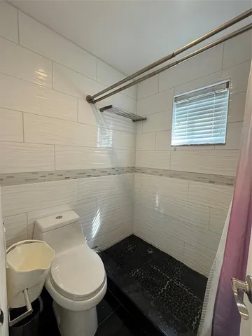 a bathroom with a toilet and a shower