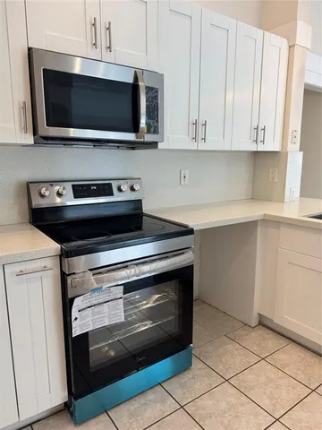 a kitchen with granite countertop a stove and a microwave