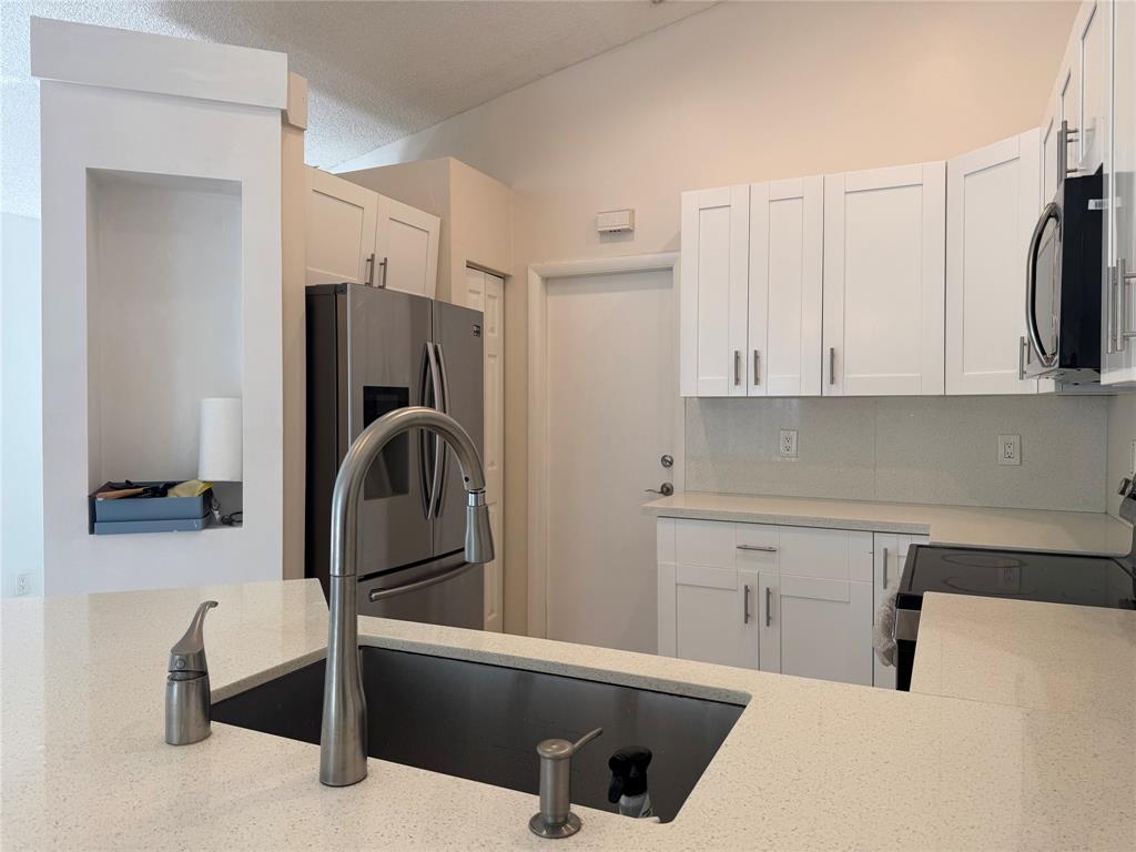 4077 Pine Ridge Lane Weston, FL 33331 - Photo 5 of 25 a kitchen with a refrigerator and a sink