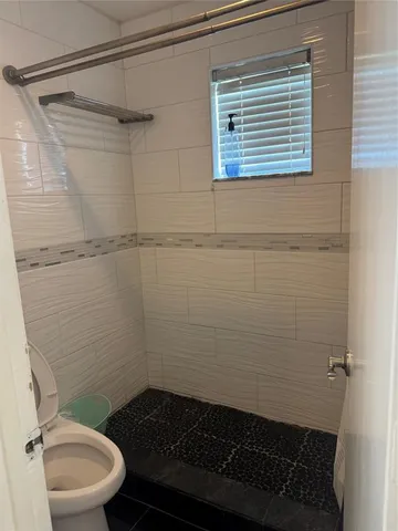 a bathroom with a toilet and a shower
