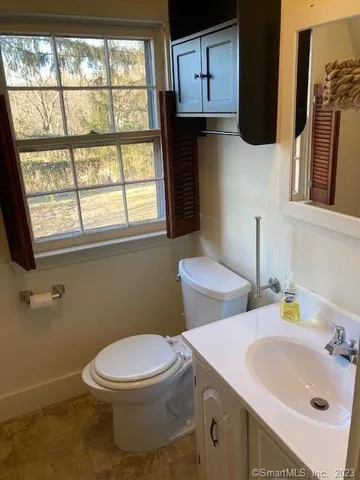 a bathroom with a sink a toilet and a window