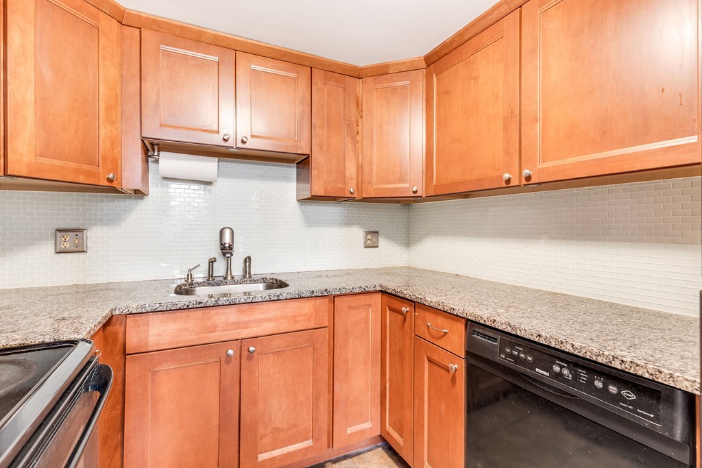 12 Locust Street, Unit 3D Everett, MA 02149 - Photo 12 of 24 a kitchen with granite countertop a sink a stove and cabinets