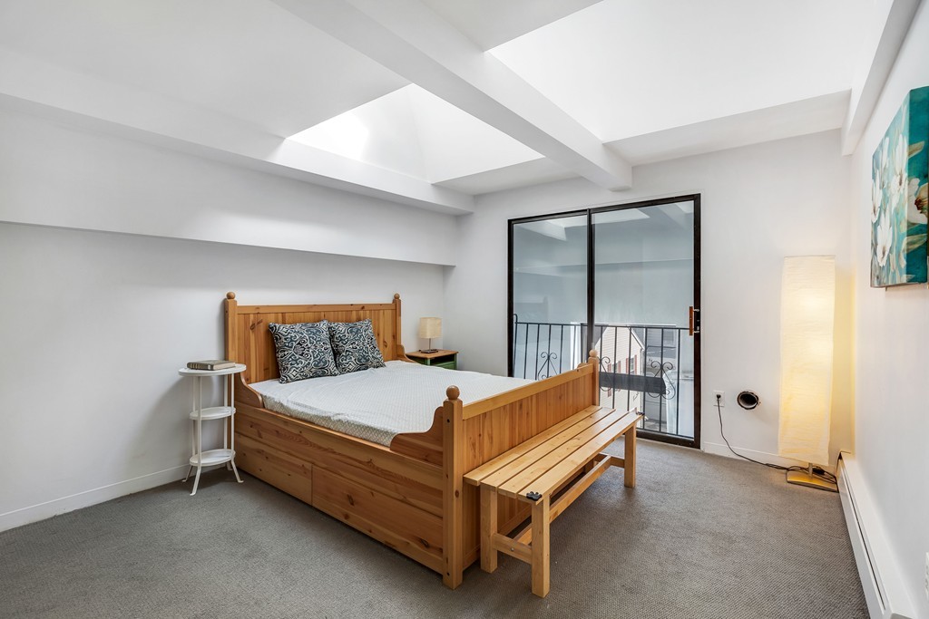 12 Locust Street, Unit 3D Everett, MA 02149 - Photo 19 of 24 a bed sitting in a bedroom next to a window