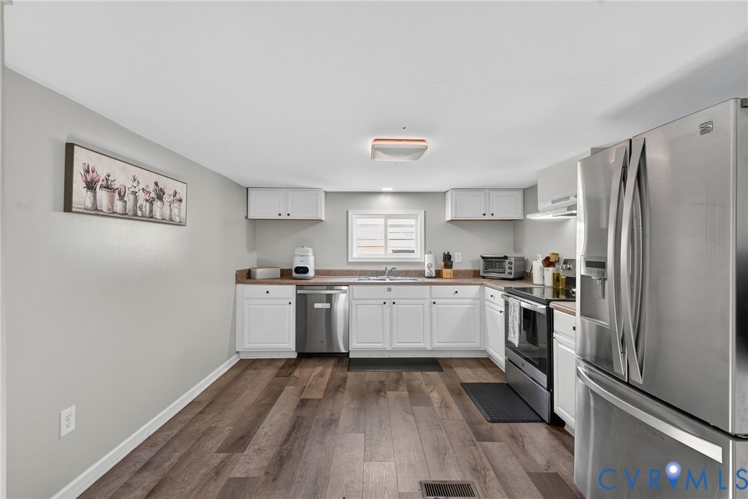 7436 Richmond Road Williamsburg, VA 23188 - Photo 26 of 44 a kitchen with a refrigerator stove and wooden floors