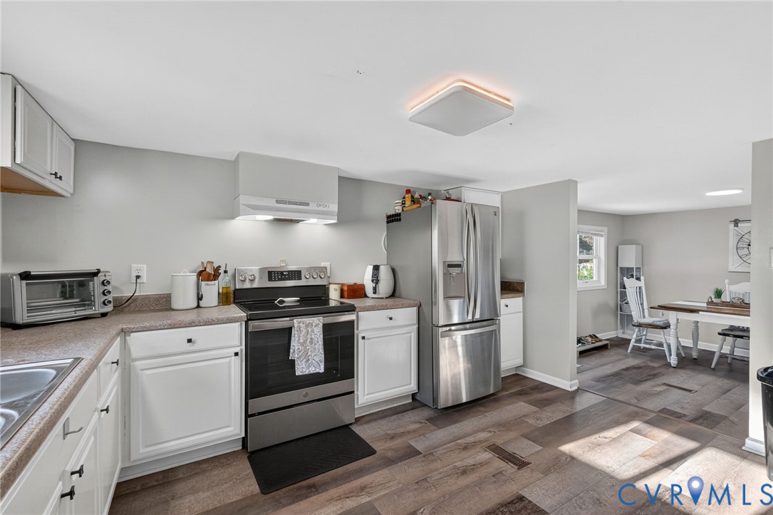7436 Richmond Road Williamsburg, VA 23188 - Photo 28 of 44 a kitchen with stainless steel appliances a stove a refrigerator and cabinets