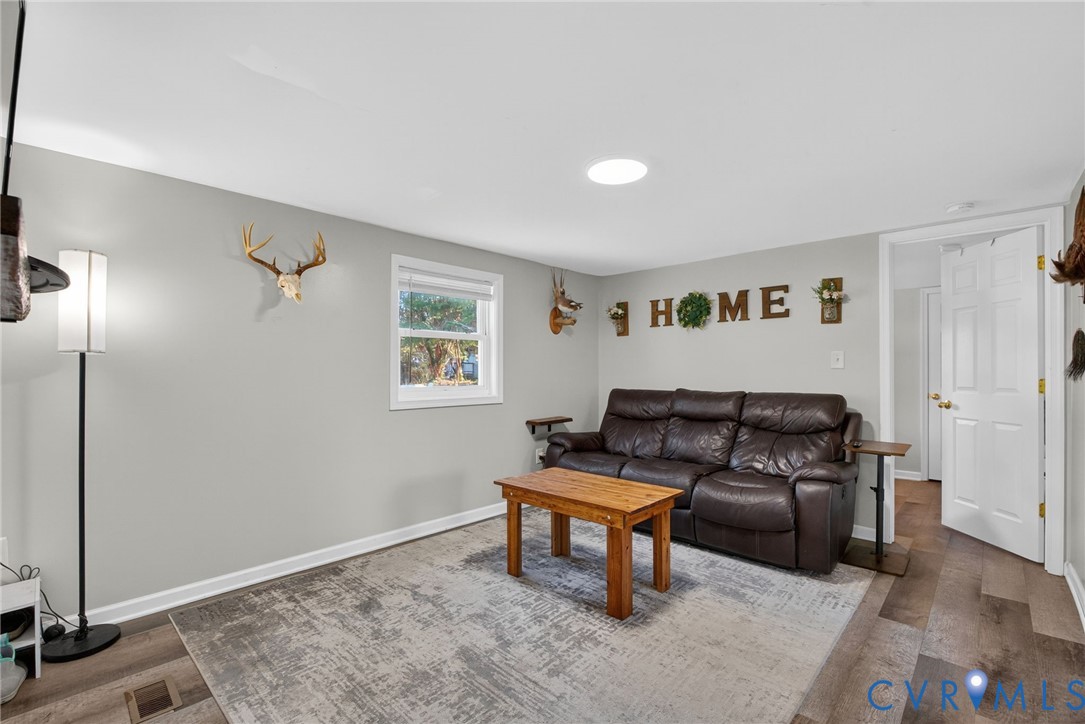 7436 Richmond Road Williamsburg, VA 23188 - Photo 31 of 44 a living room with furniture and a wooden floor
