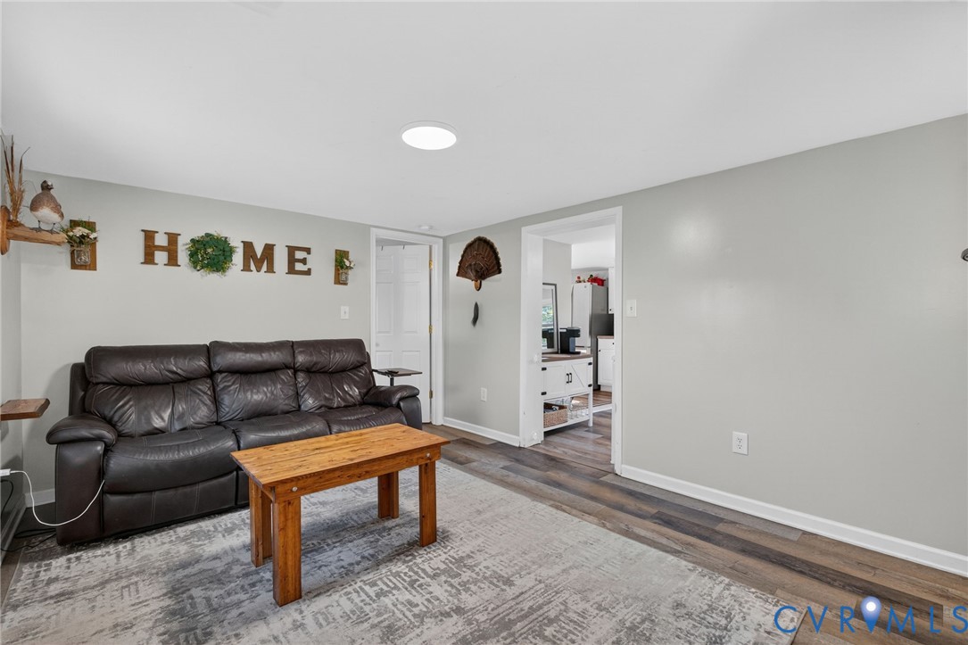 7436 Richmond Road Williamsburg, VA 23188 - Photo 32 of 44 a living room with furniture and a wooden floor