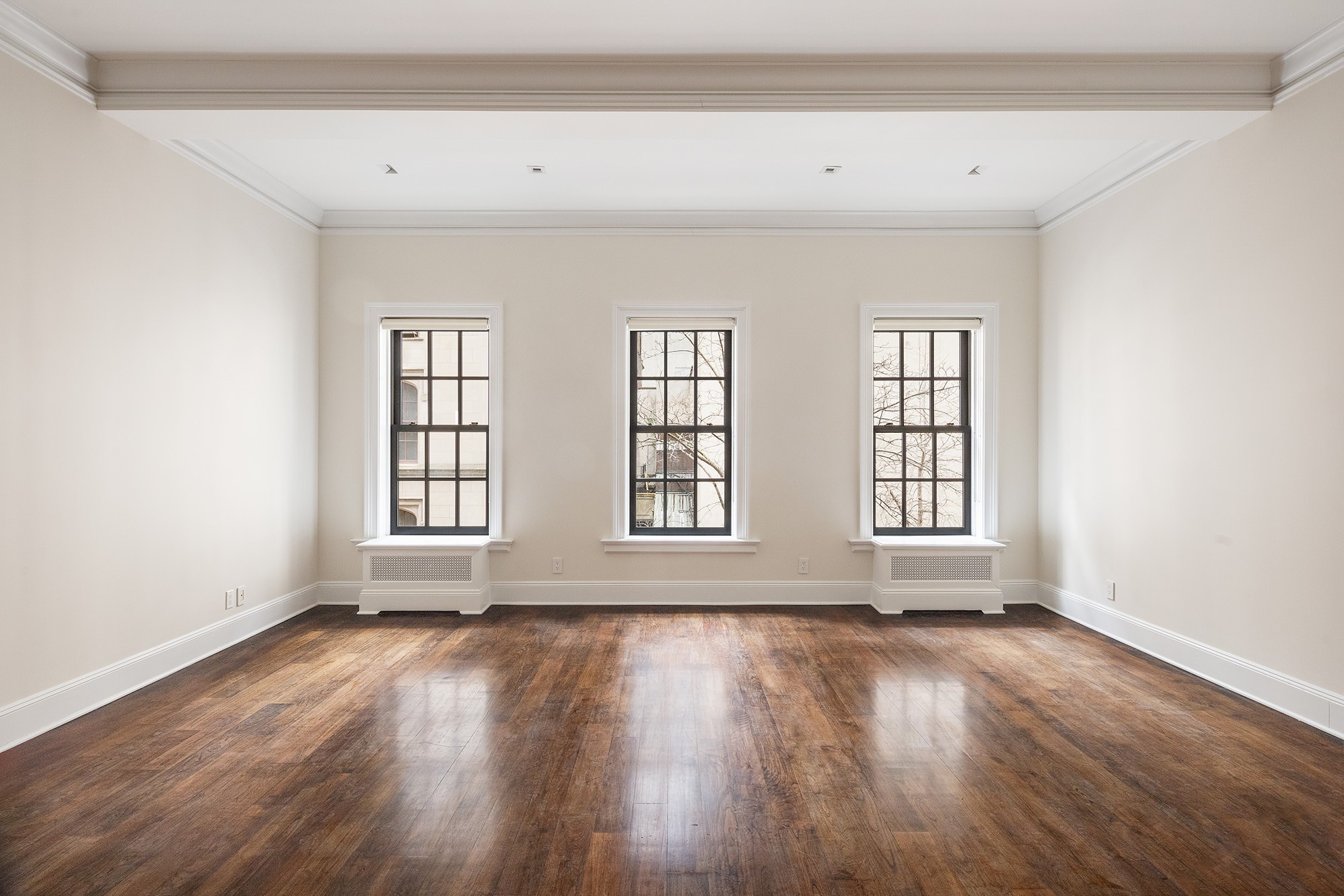 127 East 69th Street, Unit RES 3 Manhattan, NY 10021 - Photo 2 of 10 an empty room with wooden floor and windows