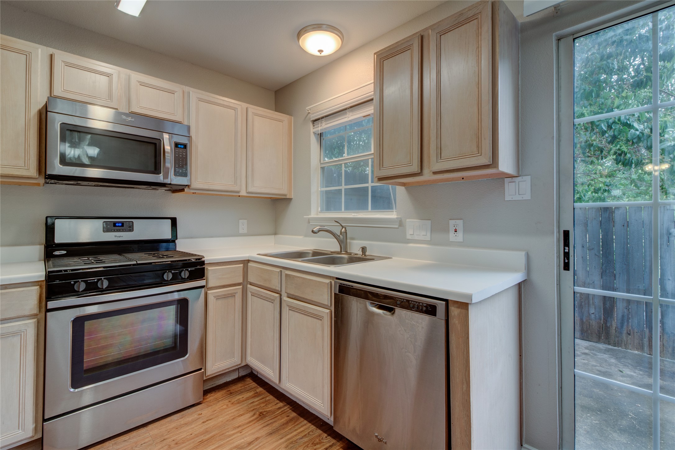 202 South College Street, Unit 9 Georgetown, TX 78626 - Photo 13 of 22 a kitchen with stainless steel appliances granite countertop a sink stove a microwave and cabinets