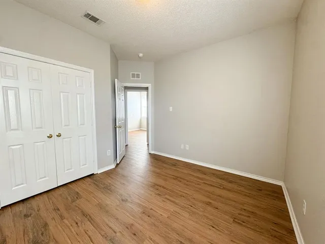 a view of an empty room with wooden floor