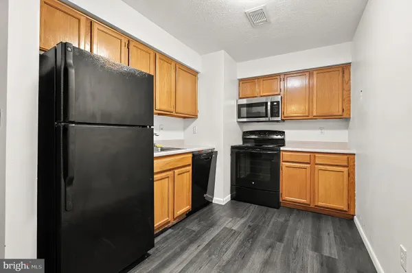 a kitchen with granite countertop a refrigerator stove and oven