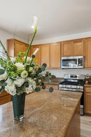 a kitchen with stainless steel appliances granite countertop a refrigerator a stove a sink and a microwave