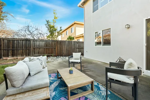 a backyard of a house with table and chairs