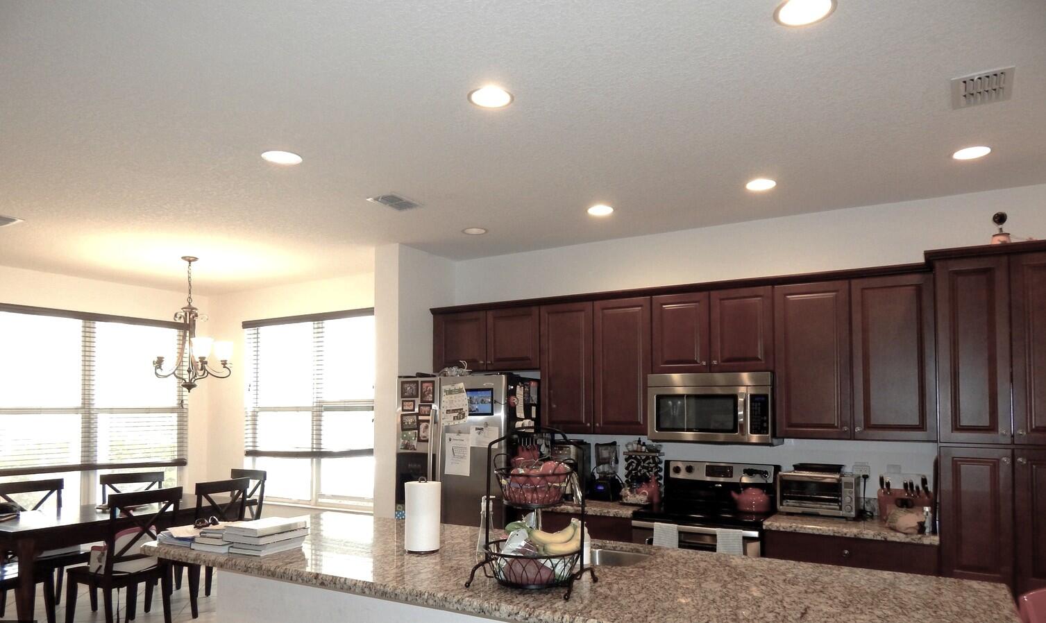 4820 Northwest 16th Terrace Boca Raton, FL 33431 - Photo 7 of 39 a kitchen with stainless steel appliances a refrigerator a stove a sink a dining table and chairs