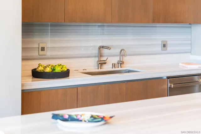 a kitchen with kitchen island granite countertop a sink and a refrigerator