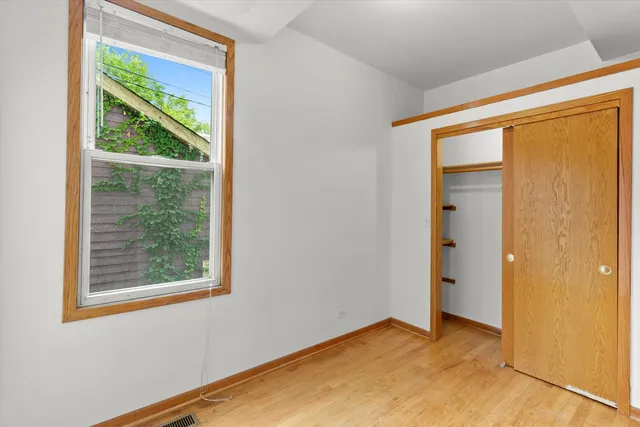 an empty room with wooden floor and a window