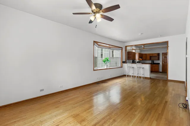 a view of a livingroom with furniture chandelier fan and windows