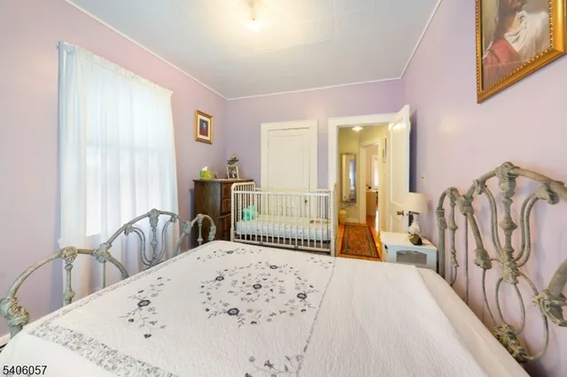 a bedroom with a bed and a large mirror on the dresser