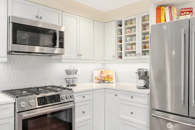 a kitchen with a refrigerator a stove top oven a sink and cabinets