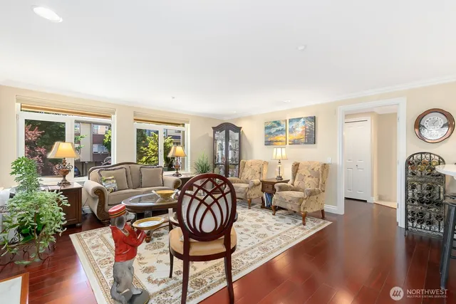 a living room with furniture a rug and a floor to ceiling window
