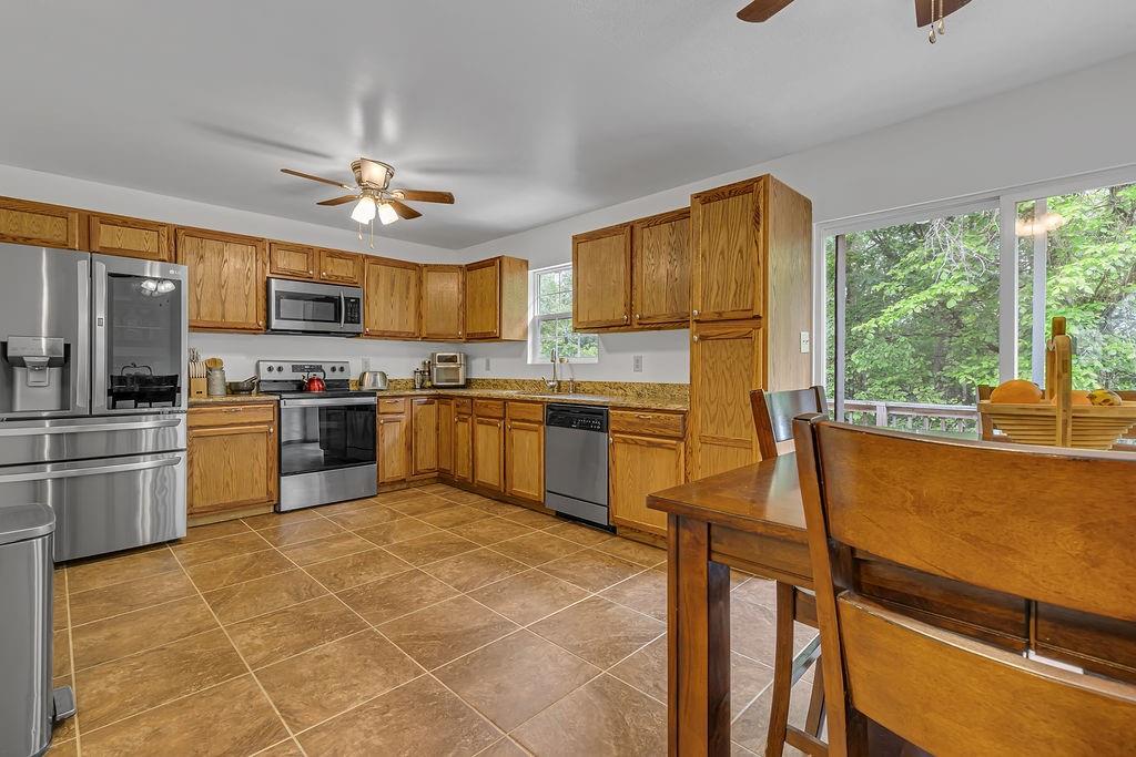 6014 Forest Drive Monaca, PA 15061 - Photo 9 of 32 a kitchen with stainless steel appliances granite countertop a stove top oven a sink dishwasher a dining table and chairs with wooden floor