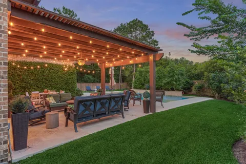 a view of a patio with table and chairs potted plants with large tree