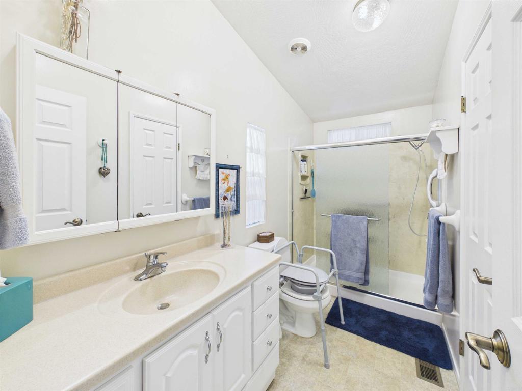 18218 Paradise Mountain Road, Unit 220 Valley Center, CA 92082 - Photo 33 of 48 a bathroom with a sink toilet a mirror and shower
