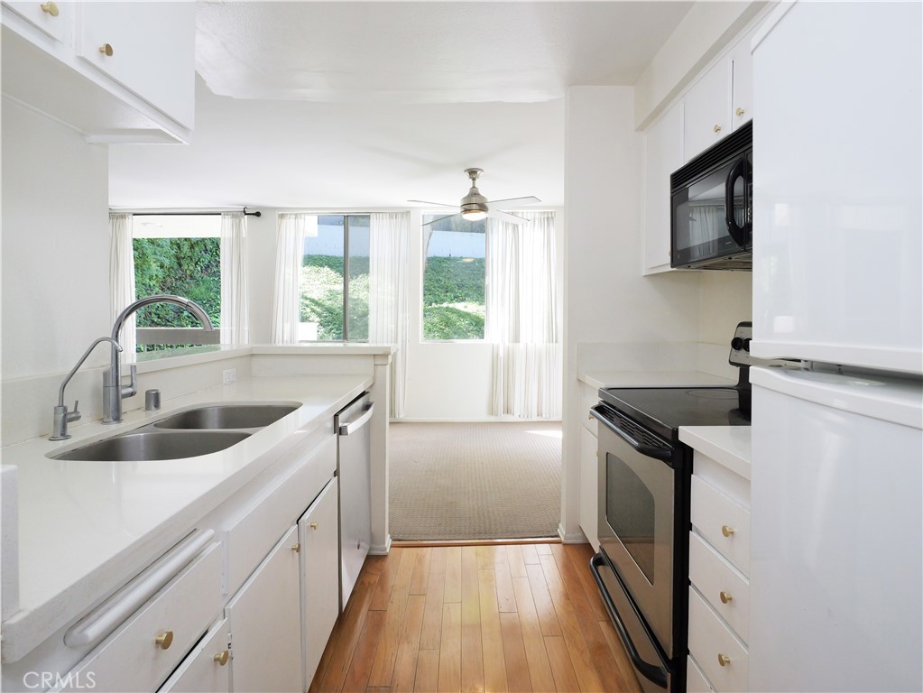 28121 Highridge Road, Unit 311 Rancho Palos Verdes, CA 90275 - Photo 7 of 25 a kitchen with granite countertop a sink and a stove top oven