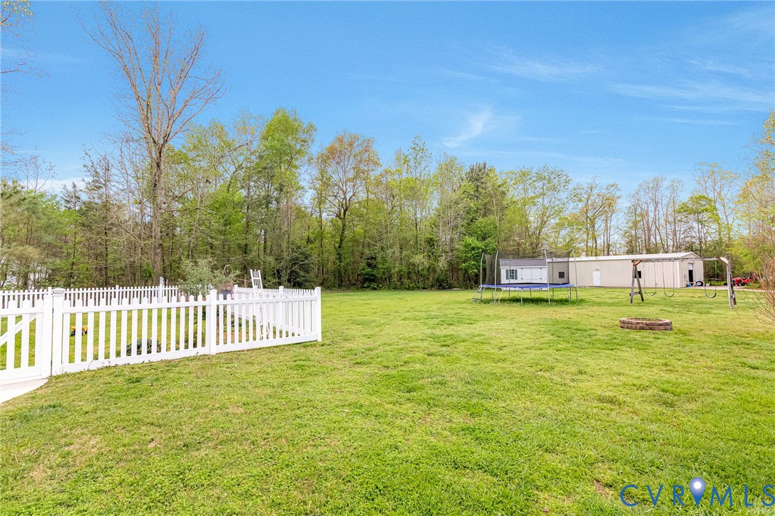 5629 West Quaker Road Disputanta, VA 23842 - Photo 40 of 43 View of yard with a trampoline and fence