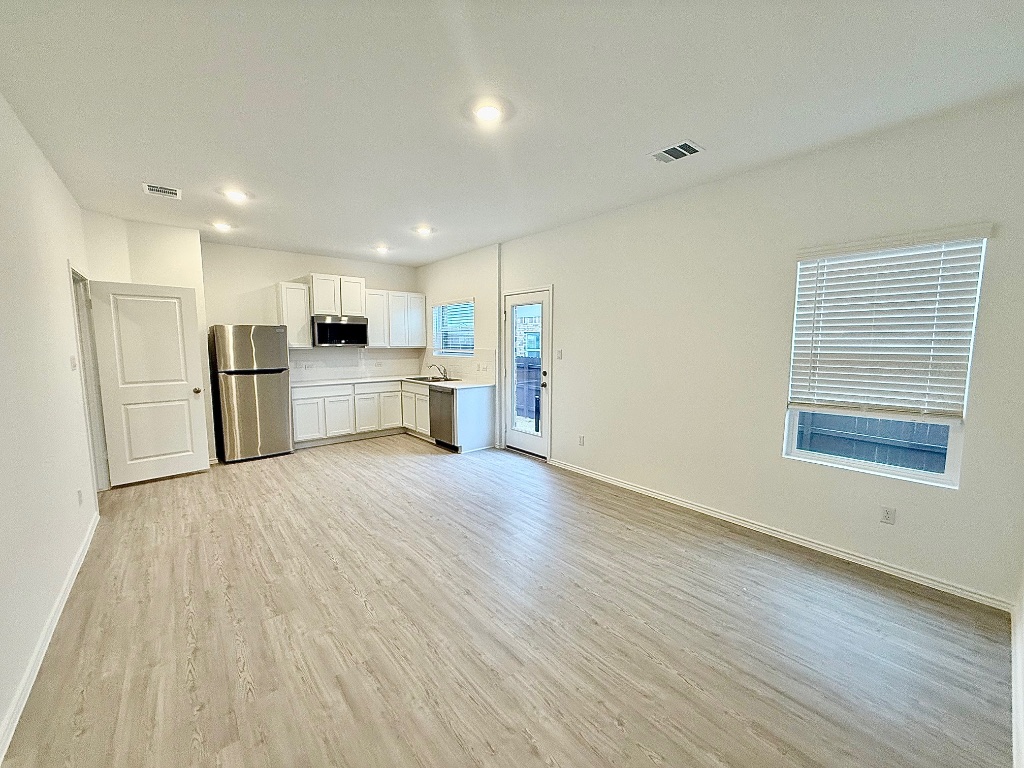 1724 Four Waters Loop Georgetown, TX 78628 - Photo 24 of 38 Gen X living room quarters with light wood-style flooring and baseboards