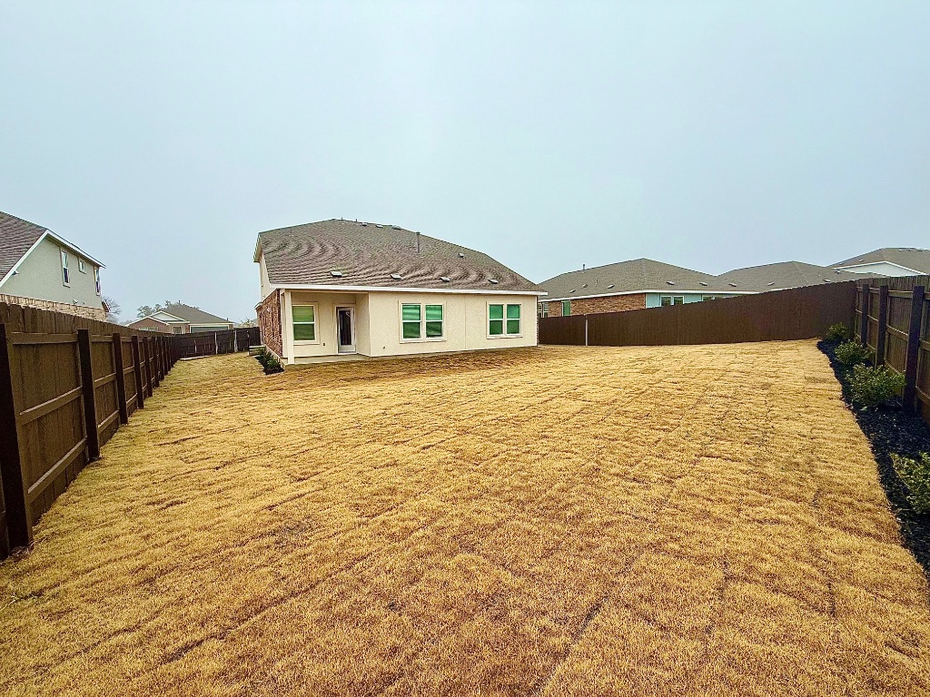 1724 Four Waters Loop Georgetown, TX 78628 - Photo 32 of 38 Back of house with a fenced backyard and a patio