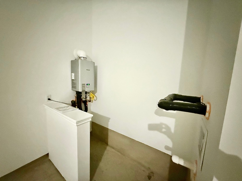 1724 Four Waters Loop Georgetown, TX 78628 - Photo 36 of 38 Laundry area featuring tankless water heater and the water softener is now installed.