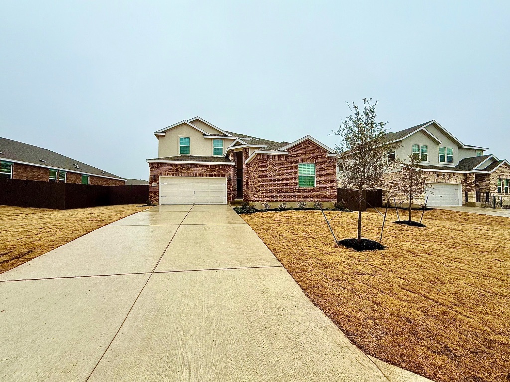 1724 Four Waters Loop Georgetown, TX 78628 - Photo 37 of 38 View of front facade featuring concrete driveway and a garage